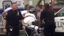 Petugas membawa Ahmad Khan Rahami ke dalam mobil ambulan di Linden, New Jersey, (19/9). Ahmad Khan Rahami, tersungkur ditanah setelah dilumpuhkan dalam adegan tembak menembak dengan polisi. (REUTERS/Anthony Genaro)