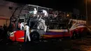 Para petugas memeriksa kerangka  bus bertingkat yang hangus terbakar di terminal bus antarprovinsi, kota Lima, Peru, Minggu (31/3). Delapan kendaraan pemadam kebakaran dikerahkan dalam insiden kebakaran alat transportasi publik terparah di Lima sepanjang sejarah. (REUTERS/Stringer)