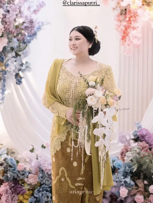 Sambil memegang buket bunga yang diberikan sang calon suami. Clarissa tampil elegan dengan gaya rambut sanggul dengan bagian depan model belah dua. Ditambah dengan tusuk konde warna keemasan. Ia pun tampil dengan anting-anting keemasannya.  [@imagenic]