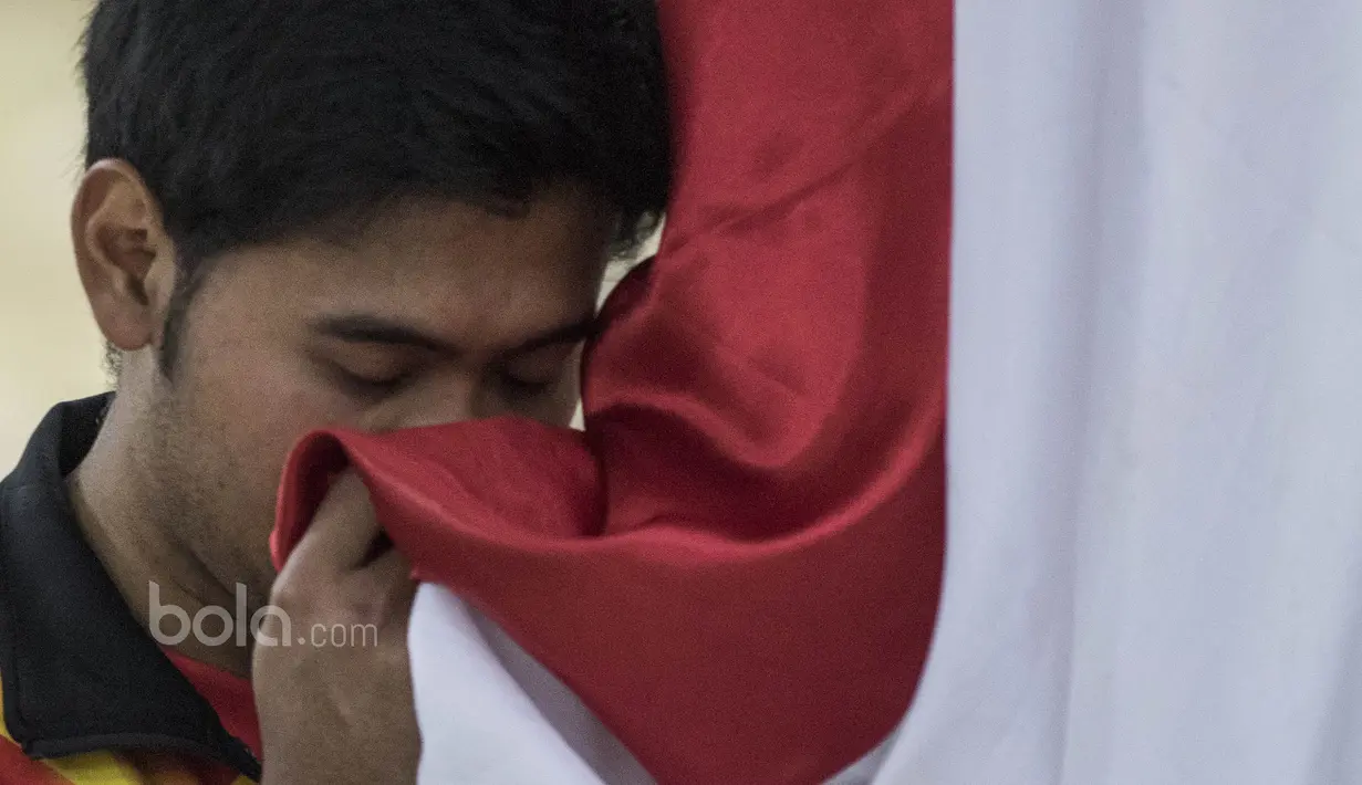 Pebulutangkis ganda putra Indonesia, Angga Pratama, mencium bendera saat seremoni pelepasan untuk Piala Sudirman di Kantor PBSI Cipayung, Jakarta, Sabtu (6/5/2017). (Bola.com/Vitalis Yogi Trisna)