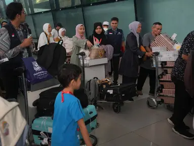 Warga Negara Indonesia (WNI) yang baru saja dievakuasi dari Lebanon setelah serangan udara Israel mendorong barang-barang mereka ke dalam troli setibanya di Bandara Internasional Soekarno-Hatta di Tangerang, Banten, Senin 7 Oktober 2024. (AP Photo/Tatan Syuflana)