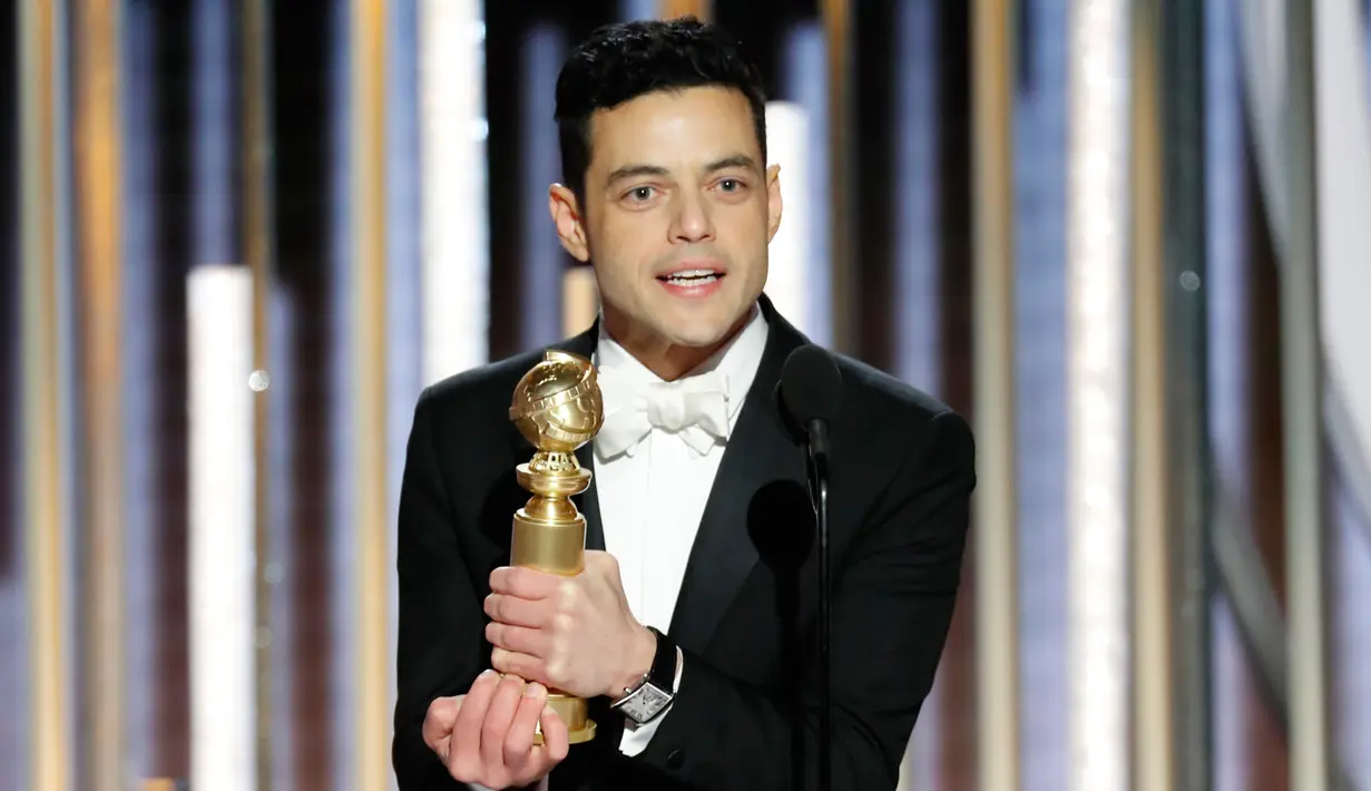 Aktor Rami Malek mengangkat penghargaan Golden Globes 2019 di The Beverly Hilton, Beverly Hills, California, Minggu (6/1). Rami Malek dinobatkan sebagai Aktor Terbaik untuk kategori film drama dalam Golden Globes 2019. (Paul Drinkwater/NBC via AP)