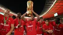 Pemain Leipzig, Christoper Nkunku (tengah) merayakan kemenangan dengan mengangkat trofi DFB Pokal atau Piala Liga Jerman bersama rekan setimnya usai mengalahkan SC Freiburg pada partai final yang berlangsung di Stadion Olimpiade di Berlin, Jerman, Sabtu, 21 Mei 2022 waktu setempat. Die Bullen berhasil menang lewat babak adu penalti dengan skor 4-2 usai laga berjalan imbang 1-1. (AFP/Ronny Hartmann)