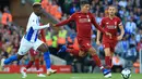 Penyerang Liverpool, Roberto Firmino berusaha menendang bola dari kawalan pemain Brighton and Hove Albion, Yves Bissouma saat bertanding pada lanjutan Liga Inggris di Anfield Stadium (25/8). Liverpool menang atas Brighton 1-0. (AFP Photo/Lindsey Parnaby)