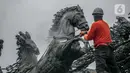 Pekerja membersihkan patung kuda Arjuna Wijaya di Jalan Medan Merdeka, Jakarta, Rabu (27/1/2021). Patung yang dibangun sejak 1987 karya pematung Nyoman Nuarta tersebut dibersihkan dan ditata kembali untuk memperindah kota. (Liputan6.com/Faizal Fanani)