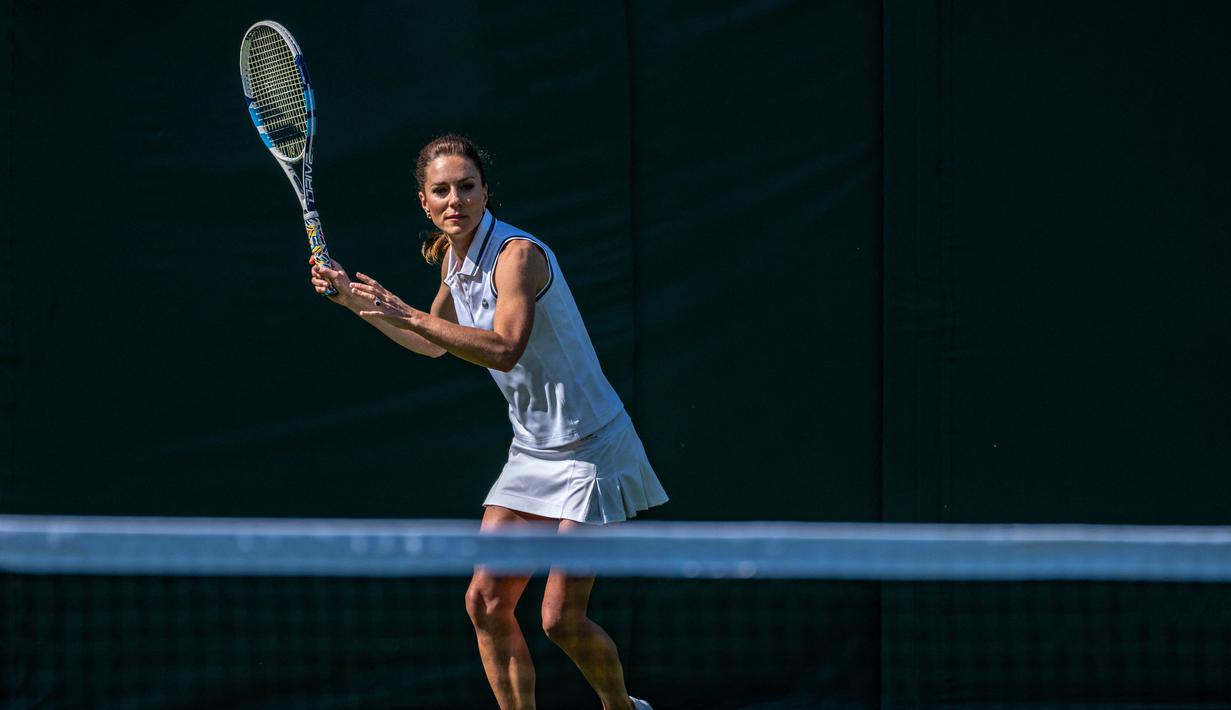 Princess of Wales, Kate Middleton, memukul bola dalam sebuah pertandingan ekshibisi melawan Roger Federer jelang Turnamen Tenis Grand Slam Wimbledon 2023 di The All England Tennis Club in Wimbledon, Sabtu (24/6/2023). (AFP/AELTC/Thomas Lovelock)