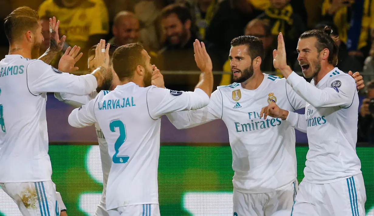 Pemain Real Madrid, Gareth Bale bersama rekan setimnya berselebrasi setelah mencetak gol ke gawang Borussia Dortmund dalam lanjutan Liga Champions di Signal Iduna Park, Rabu (27/9). Satu gol Bale mewarnai kemenangan Real Madrid 3-1. (AP/Michael Probst)
