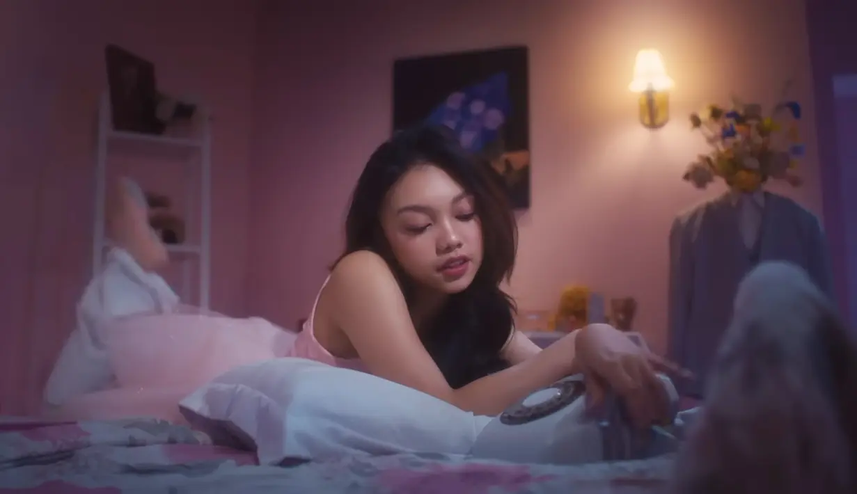 Dominasi shade pink terlihat di sepanjang music video. Naura menggambarkan perasaan rindu dengan visual yang dreamy. [YouTube Trinity Optima Production]