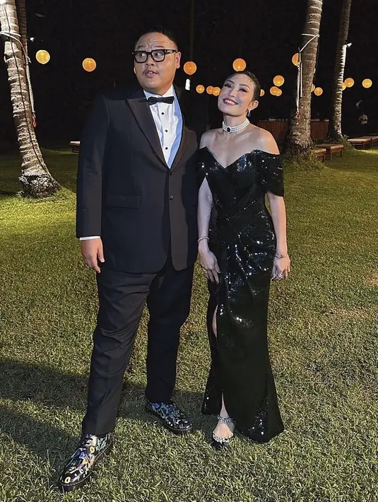 Ayu Dewi juga hadir bahkan sebagai MC, ia mengenakan one shoulder dress sequin warna hitam. Lengkap mengenakan aksesori kalung layering mutiara. [@rezachandika]
