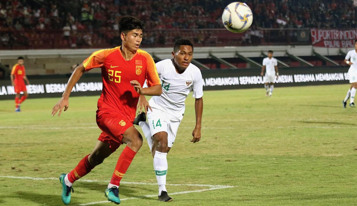 Pemain China U-19, Tayier Xiaokaitijiang, berebut bola dengan gelandang Timnas Indonesia U-19, Fajar Fathur Rachman, pada laga ujicoba di Stadion I Wayab Dipta, Bali, Minggu (20/10). Indonesia kalah 1-3 dari China. (Bola.com/Aditya Wany)