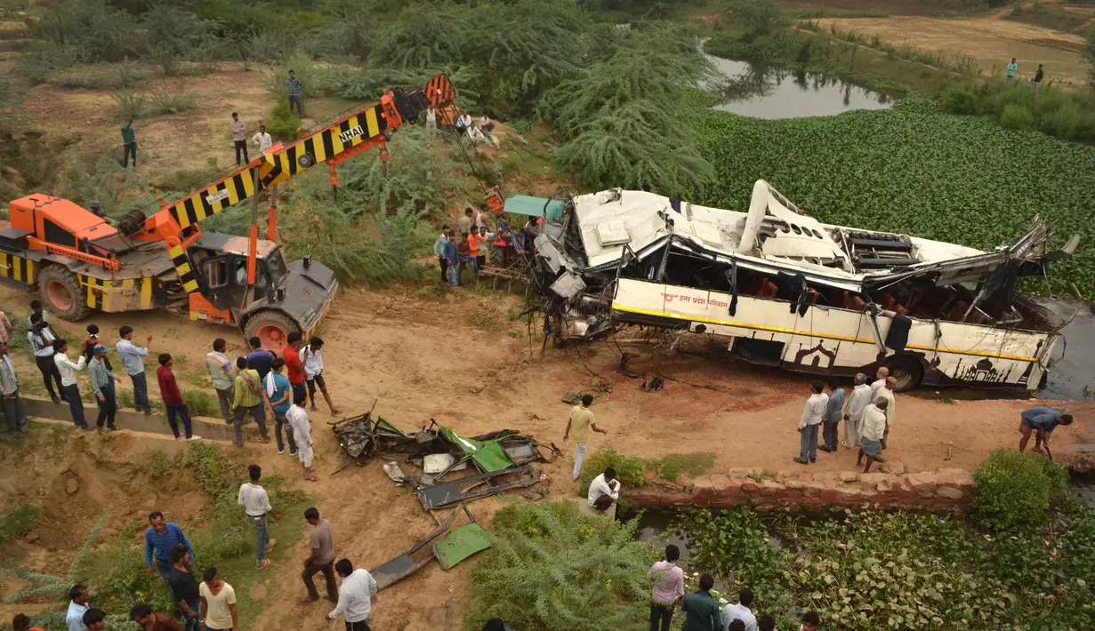 Sebuah derek menarik bus tingkat yang rusak setelah mengalami kecelakaan di jalan bebas hambatan di Agra, India, Senin (8/7/2019). Sebanyak 29 orang dilaporkan tewas dan 18 lainnya terluka dalam kecelakaan bus tersebut. (AP Photo/Pawan Sharma)