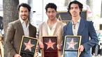 (kiri ke kanan) Kevin Jonas, Nick Jonas, dan Joe Jonas dari Jonas Brothers berpose pada upacara penganugerahan bintang Hollywood Walk of Fame di Los Angeles, Amerika Serikat, 30 Januari 2023. Bintang penghormatan terhadap Jonas Brothers berada di sekitar musikus hebat lainnya seperti Elvis Presley dan The Beatles. (Photo by Jordan Strauss/Invision/AP)