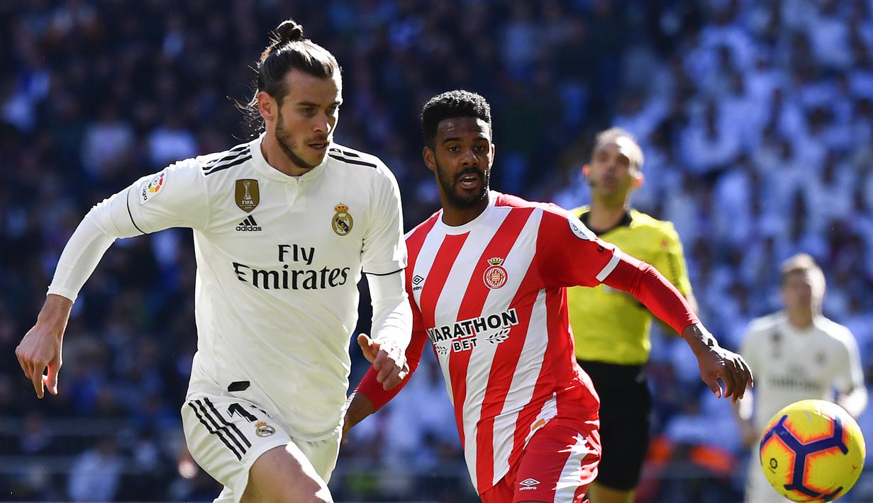 Gelandang Real Madrid, Gareth Bale, berebut bola dengan bek Girona, Jonas Ramalho, pada laga La Liga di Stadion Santiago Bernabeu, Madrid, Minggu (17/2). Madrid kalah 1-2 dari Girona. (AFP/Gabriel Bouys)