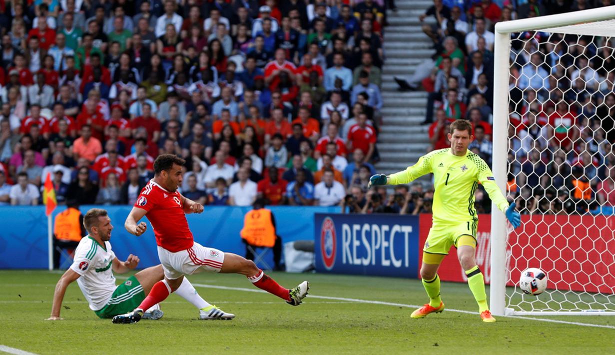 Pemain Irlandia Utara, Gareth McAuley (putih), mencetak gol bunuh diri saat melawan Wales pada laga 16 besar Piala Eropa 2016 di Parc des Princes, Paris, Sabtu (25/6/2016) malam WIB. (Reuters/John Sibley)