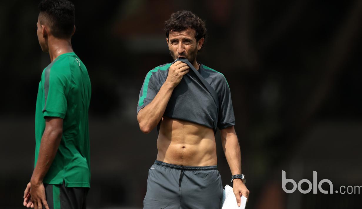 Luis Milla memperlihatkan otot perutnya tanpa sengaja pada sesi latihan Timnas U-22 Indonesia di Lapangan SPH, Karawaci, Jumat (17/3/2017). Milla adalah mantan pemain Barcelona dan Real Madrid. (Bola.com/Nicklas Hanoatubun)