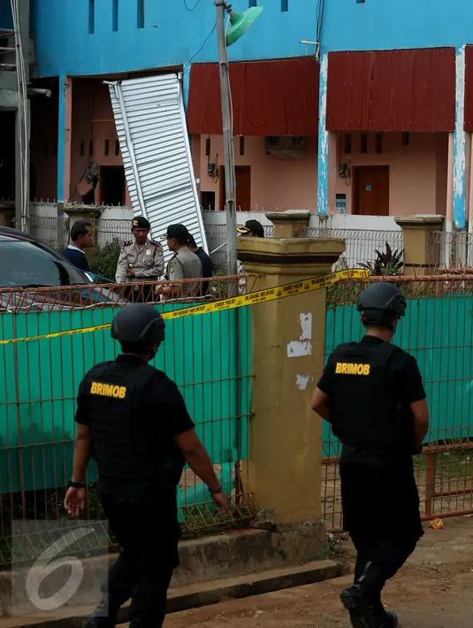 Petugas berjaga di sekitar rumah terduga anggota jaringan teroris, Bekasi, Minggu (11/12). Densus 88 menangkap tiga orang terduga anggota kelompok teroris dan menemukan bom siap ledak. (Liputan6.com/Johan Tallo)