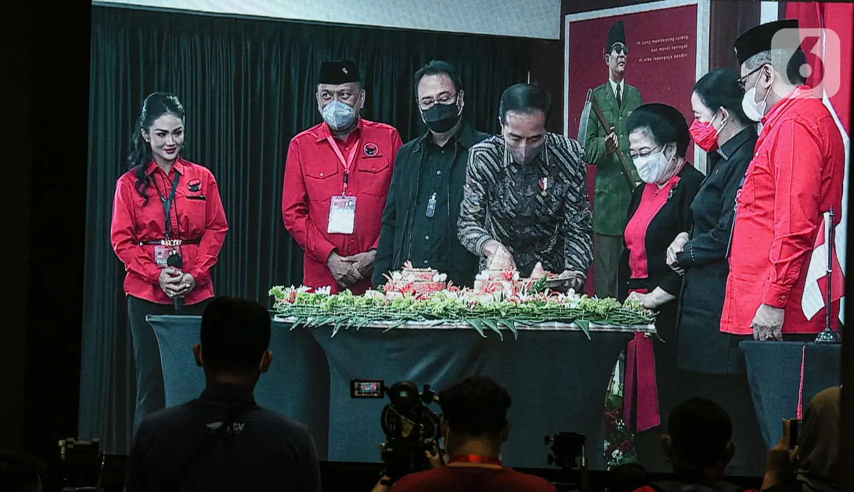 Presiden Joko Widodo atau Jokowi (tengah) memotong tumpeng disaksikan Ketua Umum PDIP Megawati Soekarnoputri (ketiga kanan) saat Rakernas II PDIP di Jakarta, Selasa (21/6/2022). Rakernas PDIP kali ini mengusung tema 'Desa Kuat, Indonesia Maju dan Berdaulat'. (Liputan6.com/Faizal Fanani)