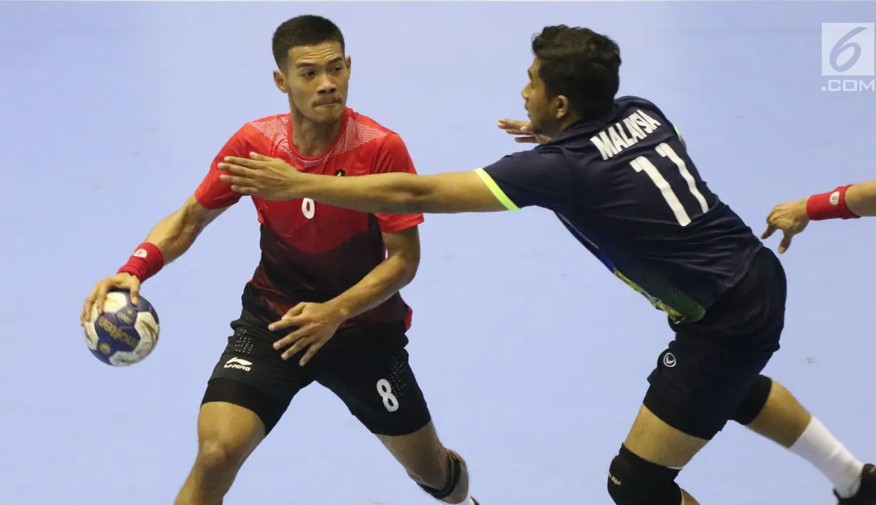 Pemain bola tangan Indonesia, Bagas (kiri) mencoba lolos dari kawalan pemain Malaysia, M Uzair Zubli pada penyisihan grup 3 bola tangan Asian Games 2018 di GOR PP POPKI, Jakarta, Minggu (26/8). Indonesia unggul 31-22. (Liputan6.com/Helmi Fithriansyah)