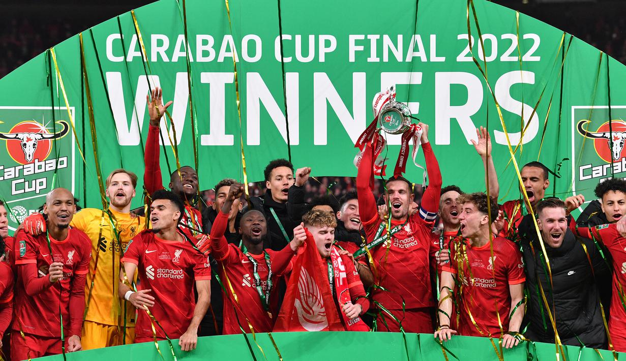 Para pemain Liverpool merayakan gelar Carabao Cup 2021/2022 setelah mengalahkan Chelsea pada laga final di Wembley Stadium, London (27/2/2022). Hingga kini Liverpool memimpin sendirian dalam perolehan trofi Piala Liga Inggris terbanyak dengan 9 kali juara. Trofi terakhir diraih The Reds pada musim 2021/2022 setelah mengalahkan Chelsea melalui adu penalti 11-10 (0-0) dalam partai final. (AFP/Justin Tallis)