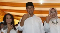 Calon Gubernur DKI Jakarta Anies Baswedan bersama istri, Fery Farhati, dan anak perempuannya menunjukkan jarinya yang telah dicelup tinta sambil berpose salam tiga jari di TPS 028 Cilandak Barat, Jakarta, Rabu (15/2). (Liputan6.com/Immanuel Antonius)