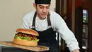 Chef dari restoran The Oak Door, Patrick Shimada berpose dengan burger raksasa di hotel Grand Hyatt Tokyo, Senin (1/4). Hamburger berisi hamparan daging wagyu yang dipotong kecil-kecil berbobot 3 kilogram itu dijual dengan harga fantastis, yaitu $900 atau setara Rp 12,8 juta. (CHARLY TRIBALLEAU/AFP)