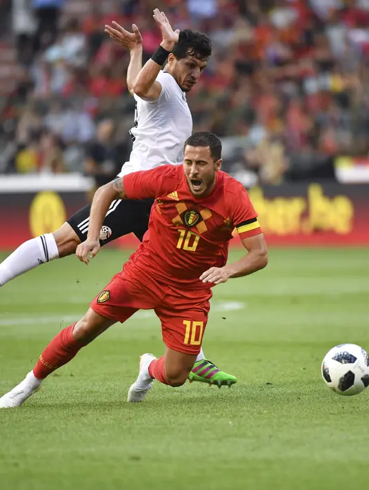 Pemain Belgia, Eden Hazard jatuh saat berebut bola dengan pemain Mesir, Tarek Hamed pada laga uji coba di King Baudouin stadium, Brussels, (6/6/2018) waktu setempat. Belgia menang 3-0.(AP/Geert Vanden Wijngaert)