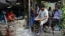 Orang-orang makan di warung pinggir jalan di Kolkata, India, Rabu (9/6/2021). India melonggarkan sebagian pembatasan untuk mengekang penyebaran virus corona COVID-19. (AP Photo/Bikas Das)