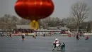 Orang-orang menggunakan kereta luncur di danau beku di Beijing pada Selasa (12/1/2021). Ketika musim dingin tiba, danau di Beijing banyak yang membeku dan dijadikan area ice skating musiman. (Photo by WANG Zhao / AFP)
