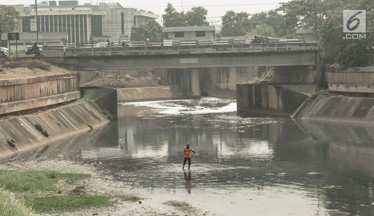 Pekerja membersihkan sampah yang mengotori aliran Kanal Banjir Timur (KBT) di Jakarta, Sabtu (15/9). Banyaknya limbah rumah tangga dan limbah industri menyebabkan kanal pengendali banjir tersebut selalu tercemari sampah. (Liputan6.com/Immanuel Antonius)