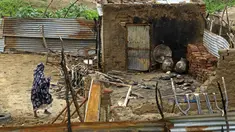 Seorang wanita berjalan ke rumahnya yang rusak setelah bentrokan etnis di negara bagian Nil Biru Sudan, di kota Roseires, Sudan tenggara (8/8/2022). Bentrokan etnis dalam sengketa tanah yang mematikan di negara bagian Nil Biru Sudan telah menewaskan 105 orang dan melukai 291, kata menteri kesehatan negara bagian itu. (AFP/Ashraf Shazly)