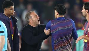 Hansi Flick coba menenangkan pemain Barcelona yang memprotes wasit usai laga kontra Atletico Madrid pada leg 1 perempat final Liga Champions 2025/2026 (Josep LAGO / AFP)