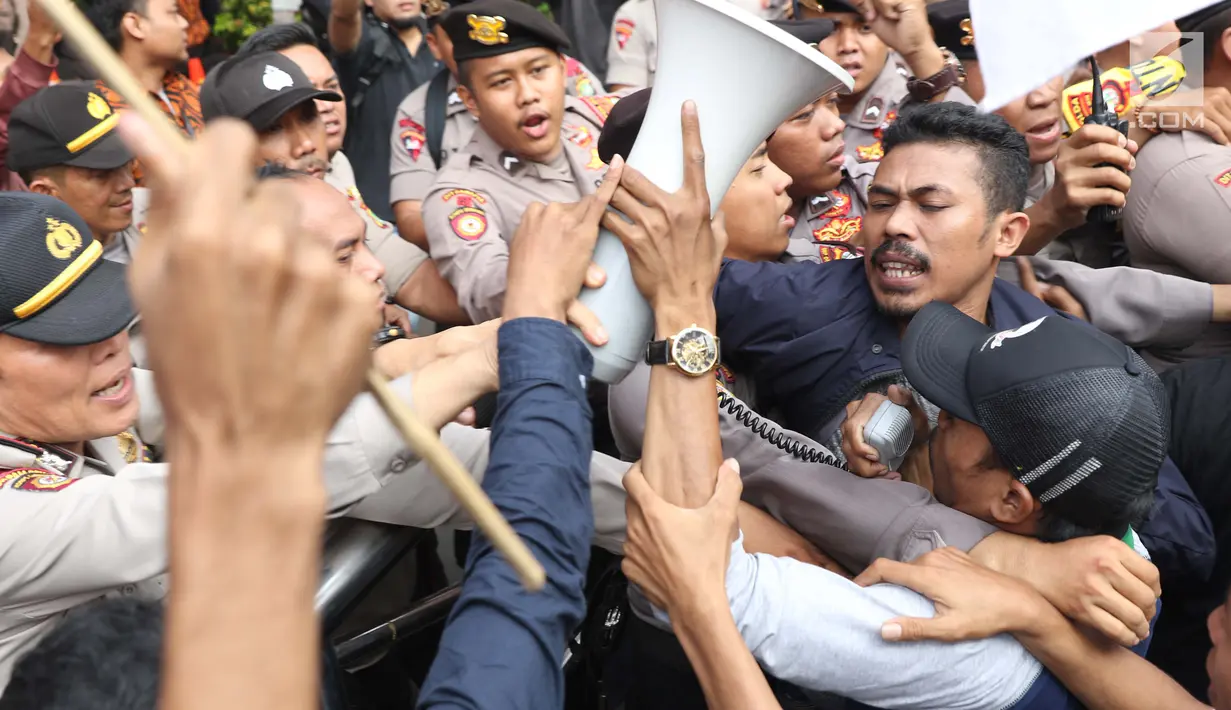 Sejumlah massa yang mengaku dari Himpunan Mahasiswa Islam terlibat aksi saling dorong dengan aparat kepolisian saat unjuk rasa di depan Gedung KPK, Jakarta, Rabu (18/9/2019). Dalam aksinya, mereka menolak pimpinan KPK terpilih periode 2019-2023. (Liputan6.com/Helmi Fithriansyah)