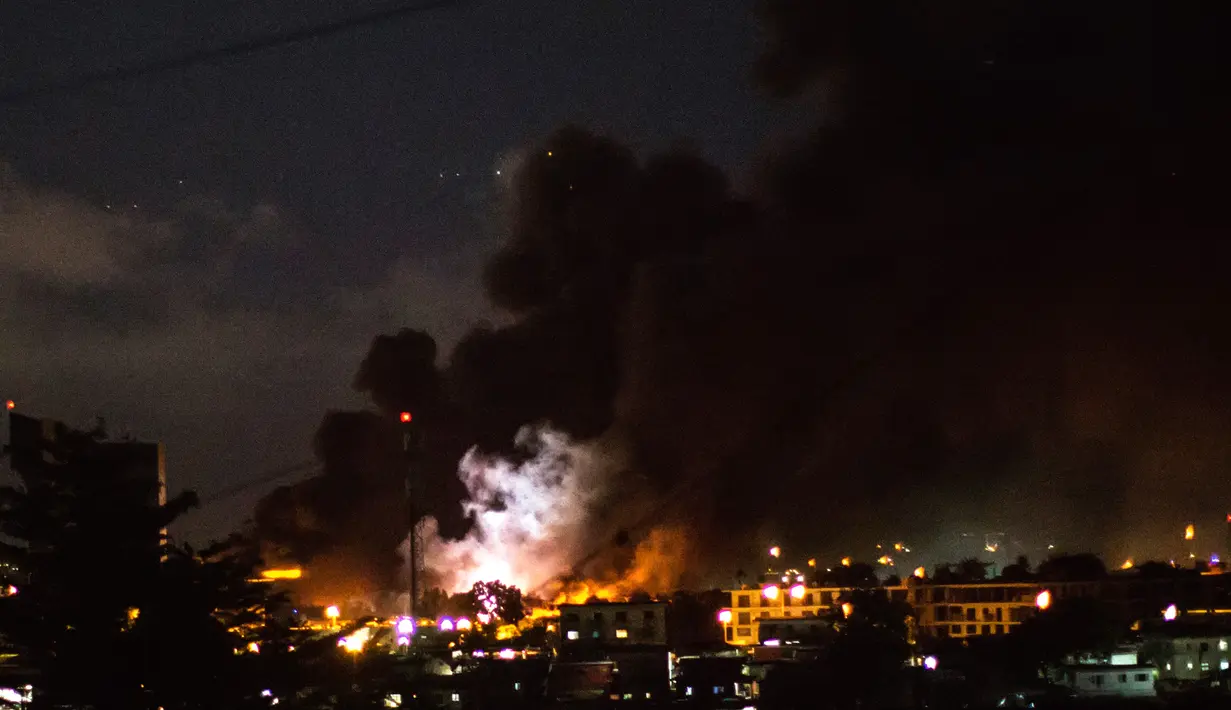 Api dan asap terlihat dari bangunan parlemen di Libreville, yang dibakar pendukung kandidat oposisi Gabon, Jean Ping, Rabu (31/8). Aksi anarkis ini dilakukan setelah Presiden Ali Bongo mendeklarasikan diri sebagai pemenang Pilpres. (MARCO LONGARI/AFP)