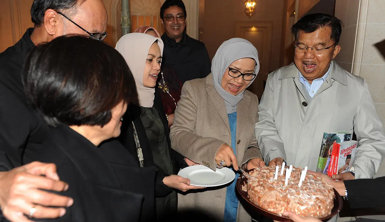 Mufidah Kalla memotong kue dan memberikannya kepada Wakil Presiden Jusuf Kalla seusai acara kejutan ulang tahun ke-77 di Jenewa, Swiss, Rabu (15/5/2019). JK berkunjung ke Swiss untuk menghadiri sebuah pertemuan yang diinisiasi PBB dengan bahasan penanganan bencana. (Liputan6.com/Tim Media Wapres)