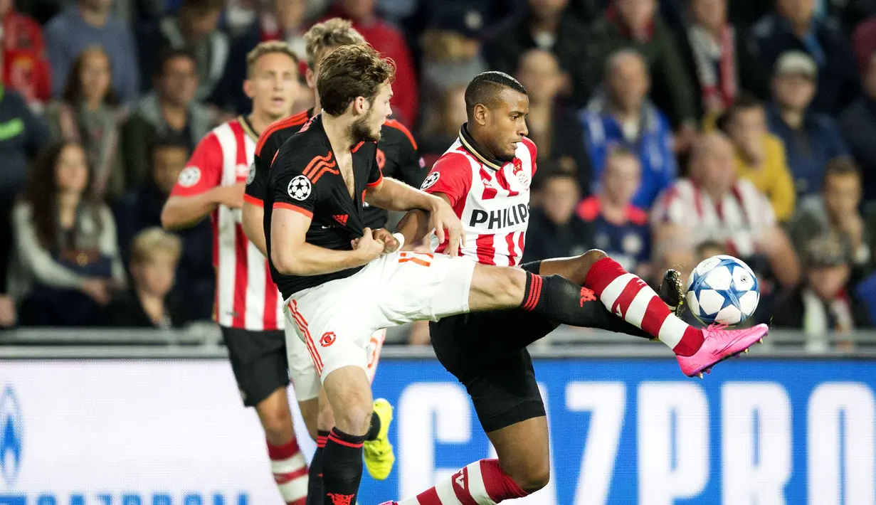  Pemain PSV Eindhoven, Luciano Narsingh (kanan) berebut bola dengan pemain Manchester United, Daley Blind pada laga UEFA Champions League di Stadion Philips, Eindhoven, Belanda, (15/9/2015). Manchester United kalah 0-2. (EPA/Olaf Kraak)