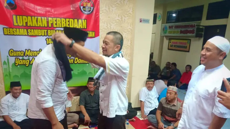 Tim Sukses Jokowi dan Prabowo di Banjarnegara saling mengalungkan sarung sebagai tanda damai dan rekonsiliasi usai pemiu. (Foto: Liputan6.com/Polres Banjarnegara/Muhamad Ridlo)