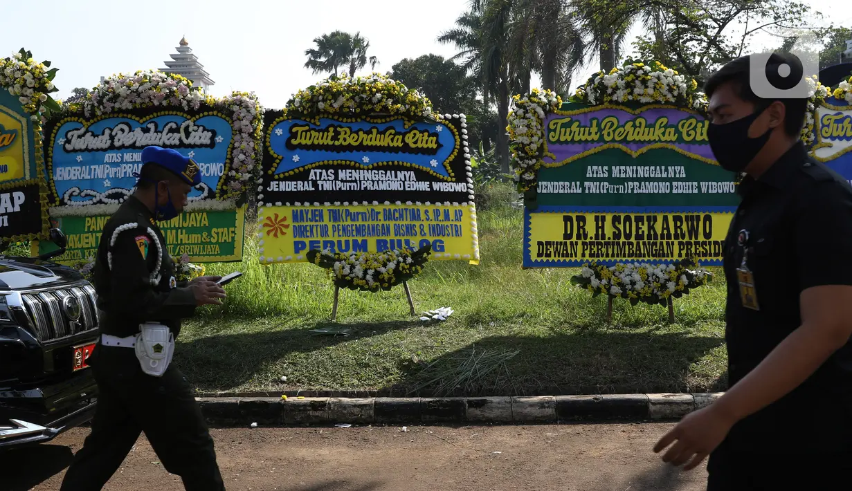 Prajurit TNI melintas di depan karangan bunga tanda duka cita atas meninggalnya mantan KSAD Jenderal TNI (Purn) Pramono Edhie Wibowo di kawasan Puri Cikeas, Kab Bogor, Jabar, Minggu (14/6/2020). Pramono Edhie Wibowo wafat di usia 65 tahun akibat serangan jantung. (Liputan6.com/Helmi Fithriansyah)