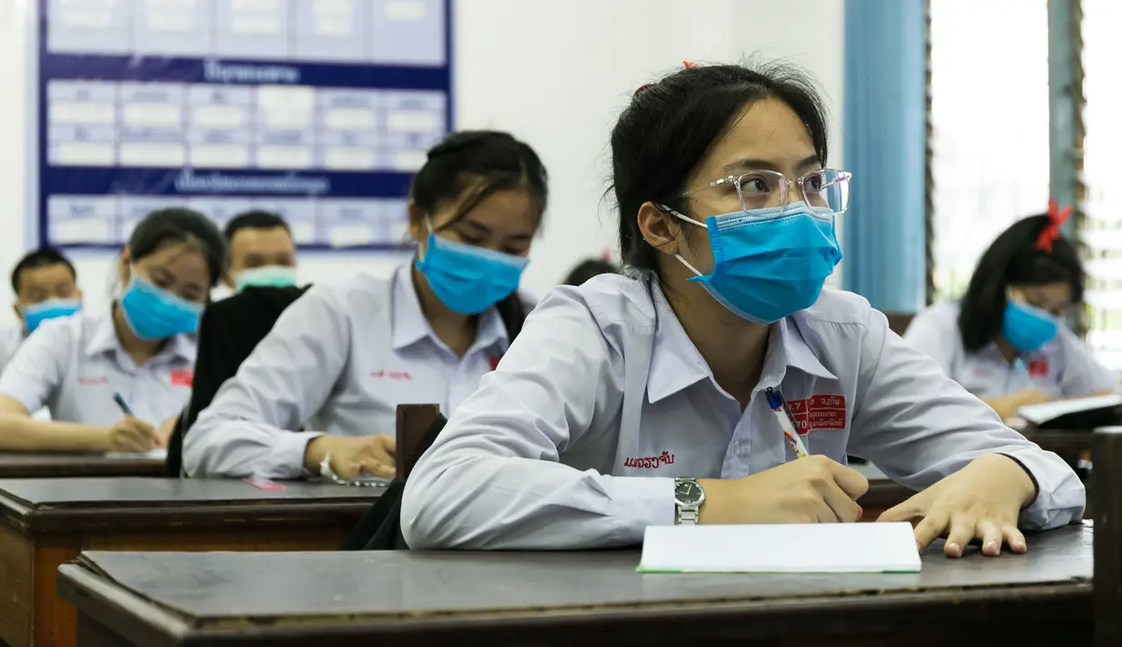 Para siswa mengenakan masker saat mengikuti kelas di sebuah sekolah di Vientiane, Laos, Selasa (19/5/2020). Siswa tingkat akhir sekolah dasar, menengah pertama, dan menengah di Laos sudah mulai bersekolah sejak 18 Mei 2020. (Xinhua/Kaikeo Saiyasane)