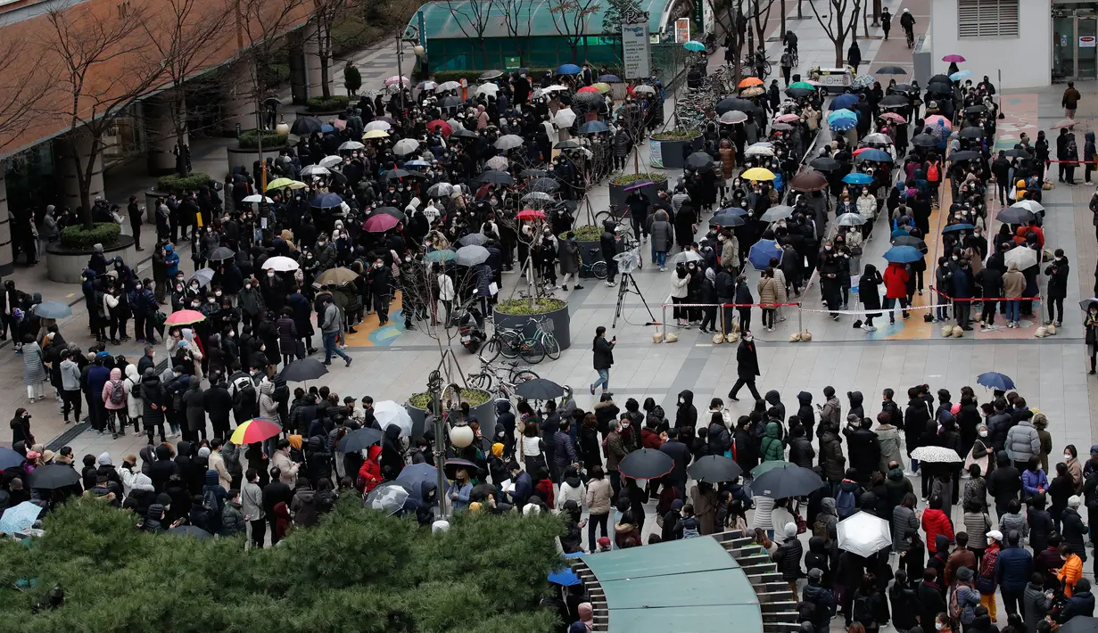 Orang-orang mengantre untuk membeli masker pelindung dari sebuah department store di Seoul, Jumat (28/2/2020).Penyebaran virus corona di Korea Selatan sendiri merupakan salah satu yang terbesar di luar China Daratan dengan kasus terkonfirmasi mencapai 1.766 orang per Jumat pagi ini. (AP/Lee Jin-man)