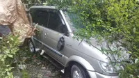 Mobil tertimpa kayu di lokasi sekitar longsor. (Liputan6.com/Reza Perdana)
