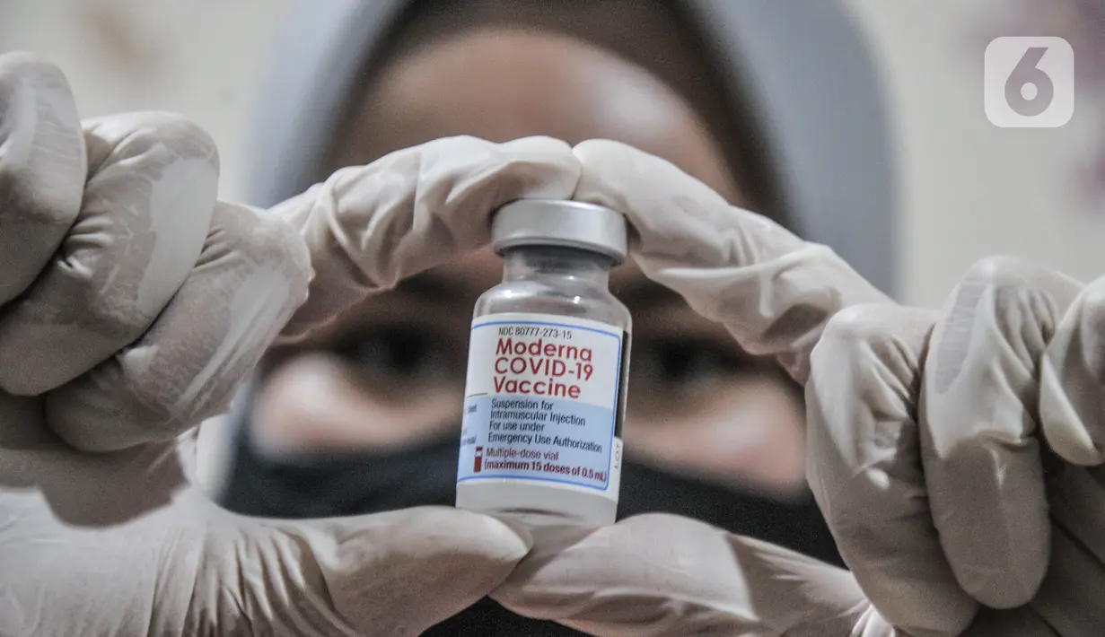 Vaksinator menunjukkan botol vaksin Moderna saat vaksinasi dosis ketiga atau booster kepada tenaga kesehatan di Puskesmas Kecamatan Cilincing, Jakarta Utara, Senin (9/8/2021). Vaksinasi booster tersebut dimaksudkan untuk memberikan proteksi tambahan kepada tenaga kesehatan. (merdeka.com/Iqbal S. Nug