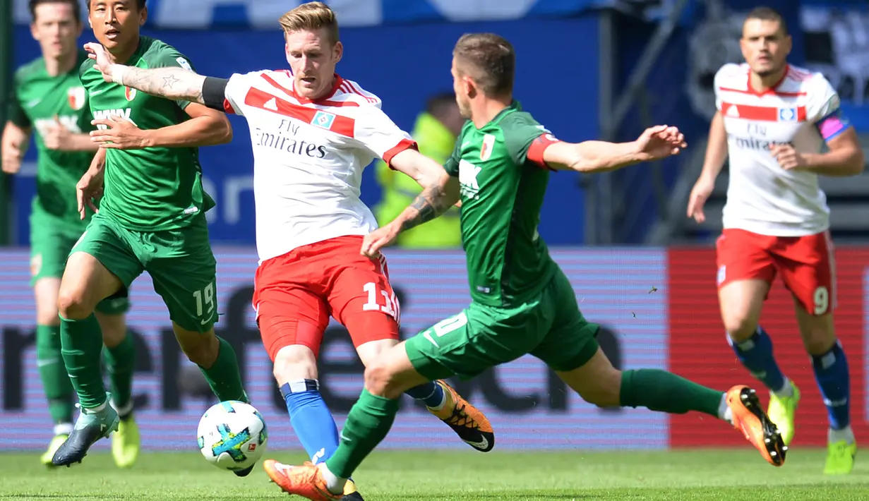 Pemain Hamburg Andre Hahn (kiri) berebut bola denga pemain Augsburg Daniel Baier saat bertanding pada Divisi Satu Bundesliga di Hamburg, Jerman (20/8). Hamburg menang 1-0 lewat gol tunggal Nicolai Mueller pada menit ke-8. (Daniel Bockwoldt /dpa via AP)