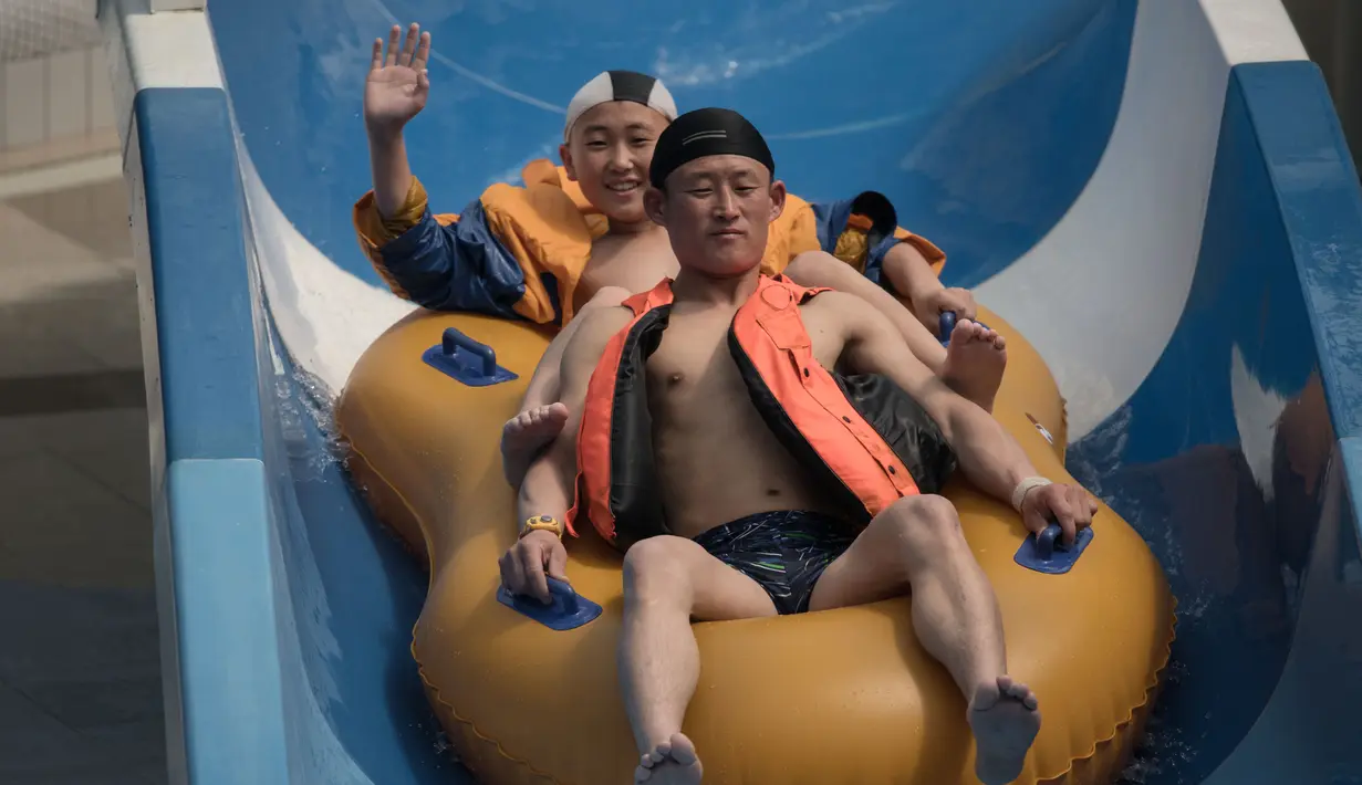 Pengunjung mencoba seluncuran air di Munsu Water Park, Pyongyang, Korea Utara, Minggu (16/4). Berbagai permainan di Munsu Water Park dijamin akan memanjakan pengunjungnya. (AFP PHOTO / ED JONES)