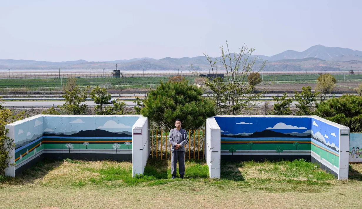 Kafe Daonsoop menjadi tempat yang hangat sekaligus bahkan unik meski tensi militer kerap terasa. Tampak dalam foto yang diambil pada tanggal 24 April 2025, kartunis Kim Dae-nyeon, berpose di antara posisi benteng untuk tank di dekat bunker (tidak terlihat) di mana dia memamerkan karya seninya dengan nama alias Danny Kim, di halaman kafe Daonsoop. (ANTHONY WALLACE/AFP)