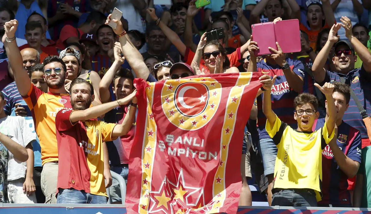 Aksi suporter saat Arda Turan diperkenalkan secara resmi kepada publik dalam suatu acara di Camp Nou, markas Barcelona. Jumat (10/7/2015). (Reuters/Gustau Nacarino)