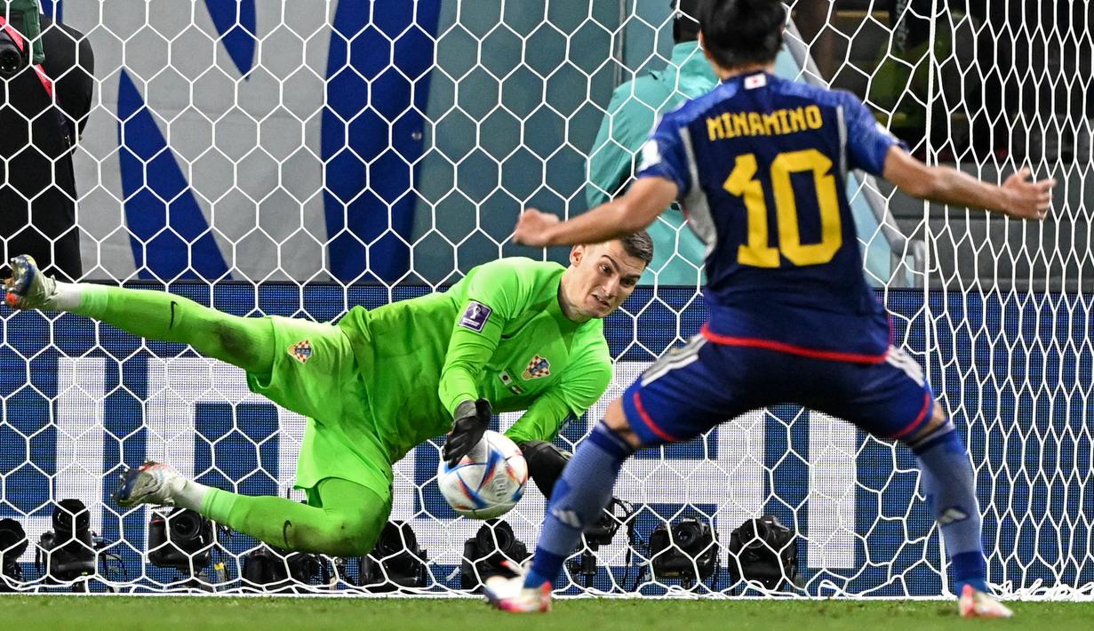 <p>Kiper Kroasia, Dominik Livakovic&nbsp;sukses menggagalkan penalti yang dilesatkan oleh Takumi Minamino&nbsp;pada laga 16 besar Piala Dunia 2022 yang berlangsung di Al-Janoub Stadium, Senin (05/12/2022). (AFP/Ozan Kose)</p>
