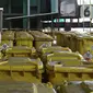 Petugas berdiri di antara tempat sampah berisi limbah B3 medis Infeksius Covid-19 yang akan dimusnahkan di PT Jasa Medivest, Karawang, Jawa Barat, Kamis (10/12/2020).  PT Jasa Medivest telah memusnahkan lebih dari 500 ton limbah B3 medis dari Maret - Oktober 2020. (Liputan6.com/Herman Zakharia)