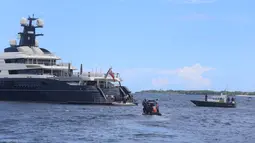 Polisi setempat mendekati kapal pesiar mewah (yacht) bernama Equanimity di Teluk Benoa, Bali, Rabu (28/2). Kapal Pesiar dengan panjang 100 meter dan berisi 34 orang kru ini memasuki perairan Bali mulai dari bulan November 2017. (Rully Prasetyo/AFP)