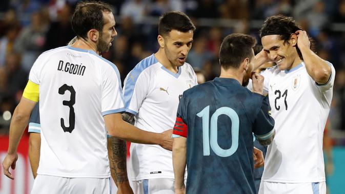 Megabintang timnas Argentina, Lionel Messi dan penyerang timnas Uruguay, Edinson Cavani selama laga persahabatan di Stadion Bloomfield, Tel Aviv, Senin (18/11/2019). Messi dan Cavani bersitegang sehingga keduanya harus sampai dipisahkan rekan-rekannya. (Jack GUEZ / AFP)