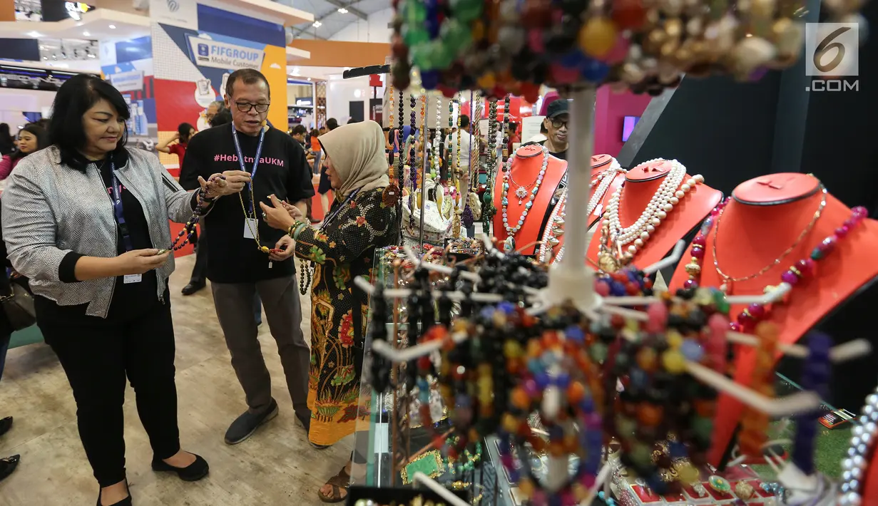 Ketua Pengurus YDBA Henry C. Widjaja (tengah), Sekretaris Pengurus YDBA, Ida R. M. Sigalingging (kiri) berbincang dengan pelaku UMKM di booth Yayasan Dharma Bhakti Astra (YDBA) GIIAS 2019, ICE BSD Tangerang, Jumat (19/7/2019). YDBA mewadahi produk unggulan Women’s Corner. (Liputan6.com/Fery Pradolo)